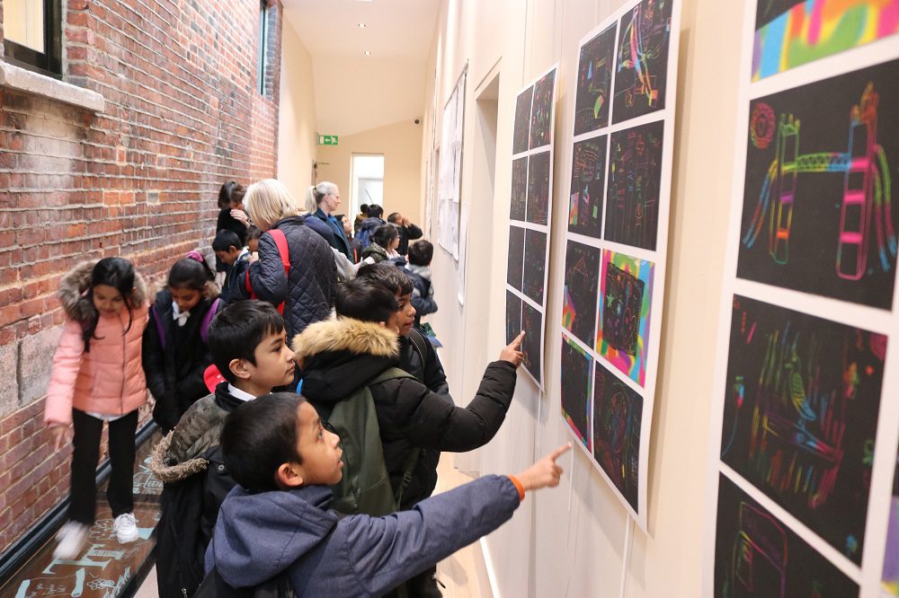 Canon Barnett School pupils look at their foil art on display