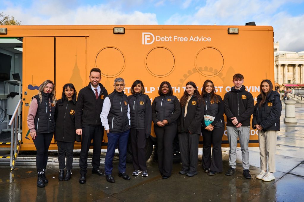 Mayor of London and Debt Free Advice team stand in front of orange Debt Bus