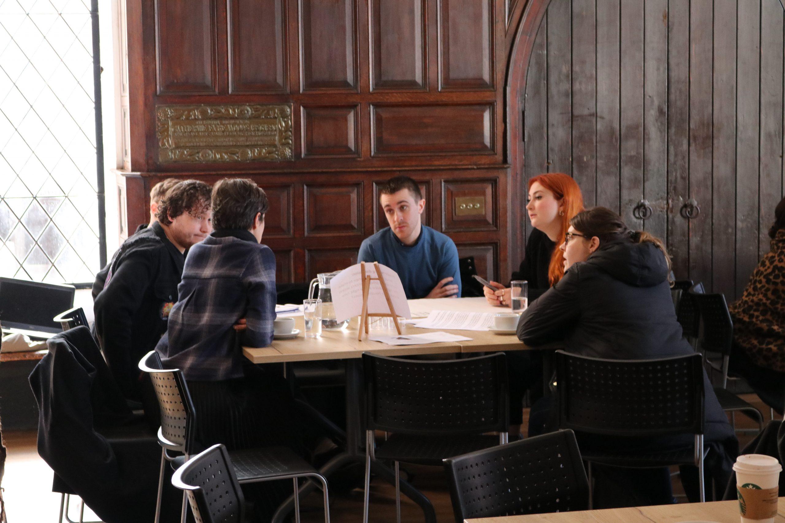 Peer researchers discuss findings around a table