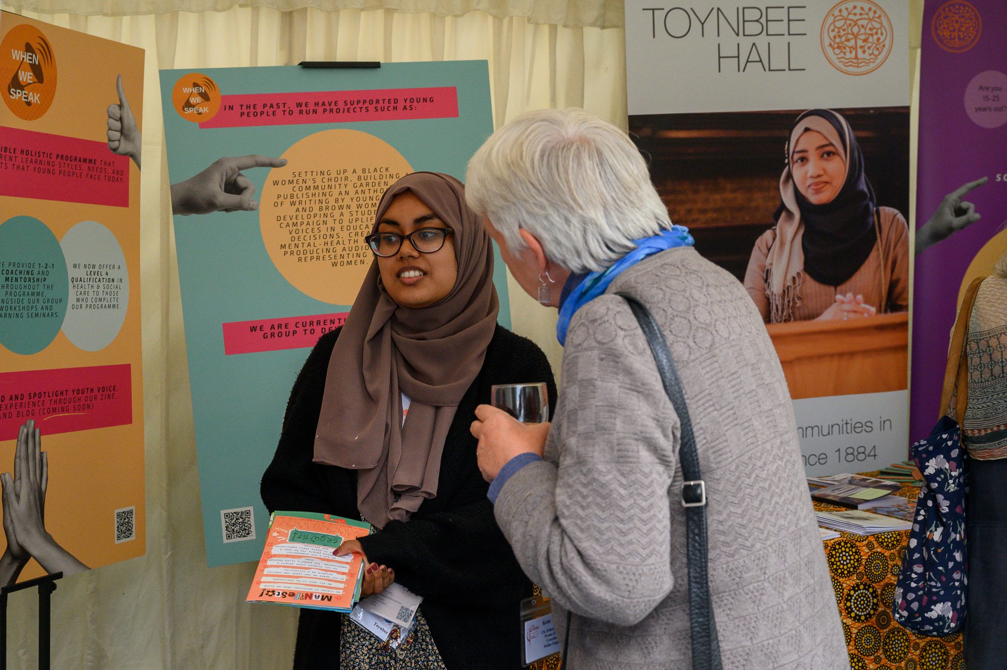Toynbee Hall youth project worker talks to attendee at Proms at St Jude's Festival