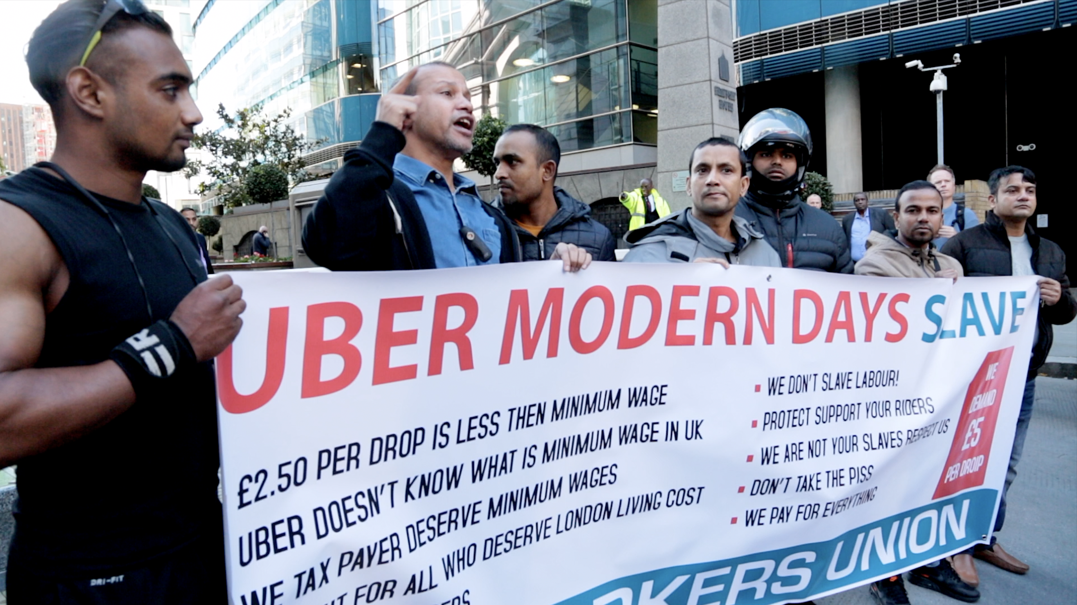 Uber drivers holding a banner while on strike