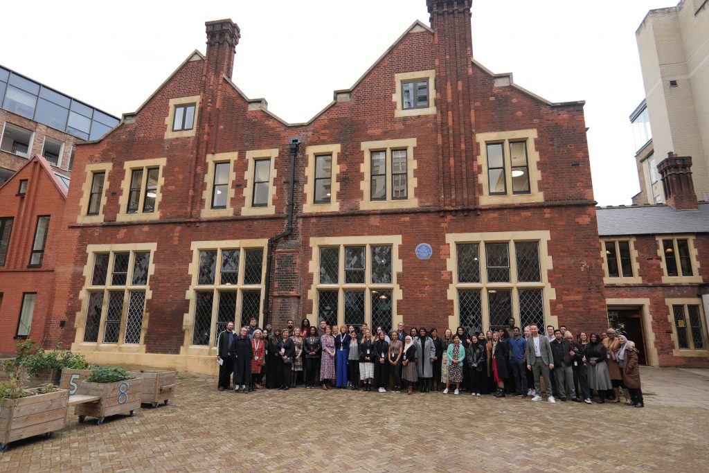 Toynbee Hall Staff stand together in the courtyard outside Toynbee Hall